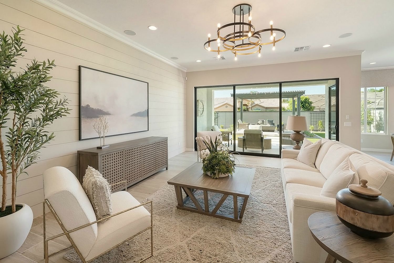 Encanto Residence Six model living room opening toward an outdoor seating area